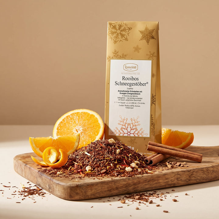 Rooibos_Schnegestoeber_Ronnefeldt, auf einem Holzbrett, Orange  und Zimt liegt daneben, Tee