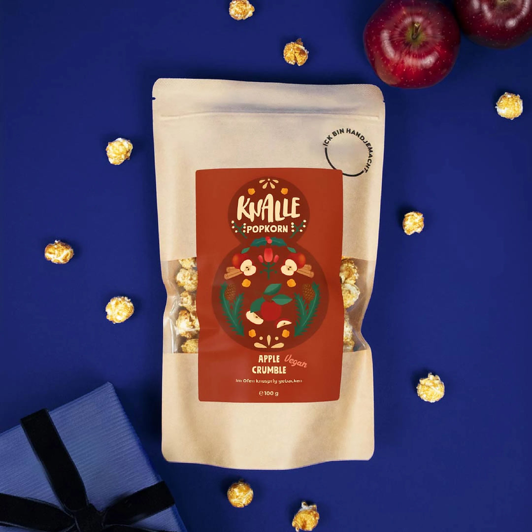 Knalle Popcorn Apple Crumble mit roten Äpfeln und Popcorn auf blauem Hintergrund