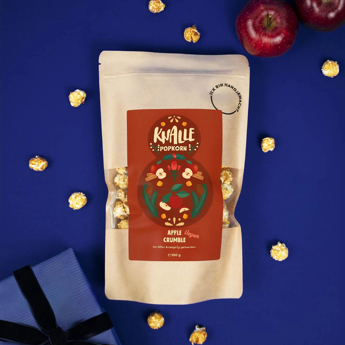 Knalle Popcorn Apple Crumble mit roten Äpfeln und Popcorn auf blauem Hintergrund
