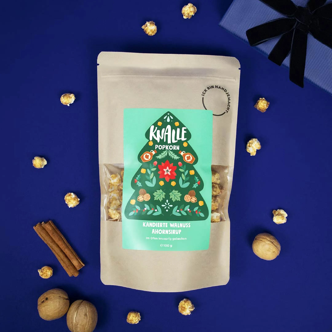 Knalle Popcorn Kandierte Walnuss Ahornsirup mit Walnüssen und Zimtstangen auf blauem Hintergrund