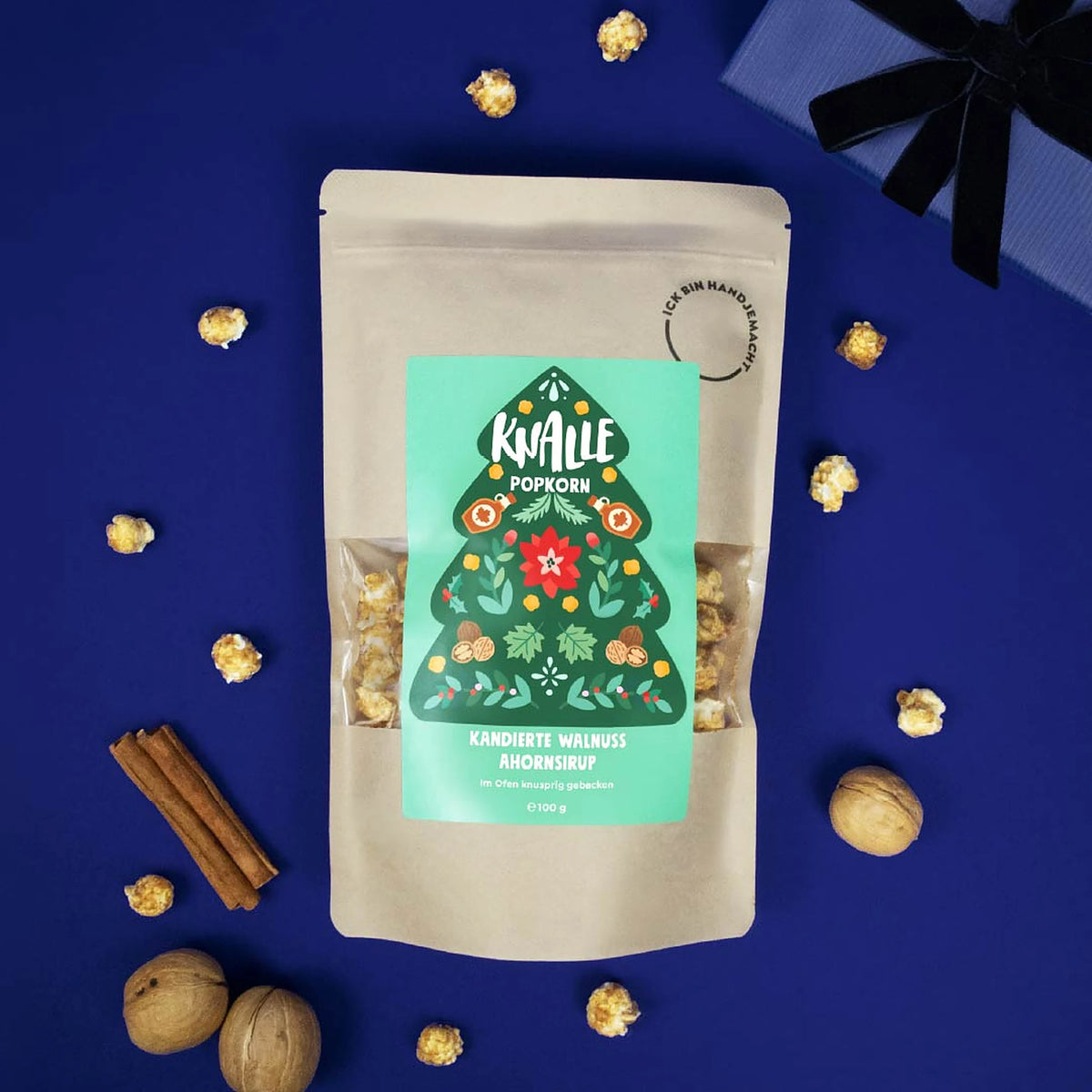 Knalle Popcorn Kandierte Walnuss Ahornsirup mit Walnüssen und Zimtstangen auf blauem Hintergrund